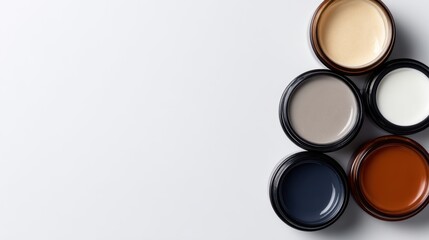 A collection of five paint jars in various colors arranged on a clean white surface, showcasing artistic potential