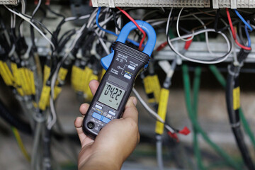 Engineer Using Clamp Meter to Measure Voltage