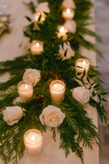 Elegant table decor with white roses and candles at an intimate gathering in a cozy space