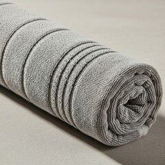 Rolled up textured towel with subtle stripes in muted green and grey tones isolated on white background
