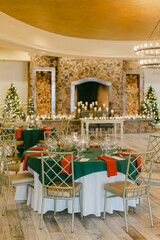 Elegant holiday dining setup with festive decor in a cozy venue showcasing a fireplace and Christmas trees