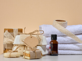 Spa and natural cosmetics items, white towels, several bars of handmade soap