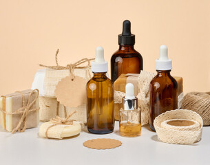 Composition of handmade soap in craft paper, bottles with oil and tags