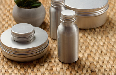 Skin care items silver metal bottles and jars on a marble tray. Natural cosmetics and spa care in the eco concept.