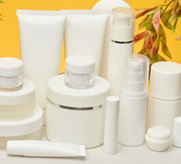 Set of white plastic cosmetic packaging without brand on yellow background. Container for beauty industry, skin care and advertising