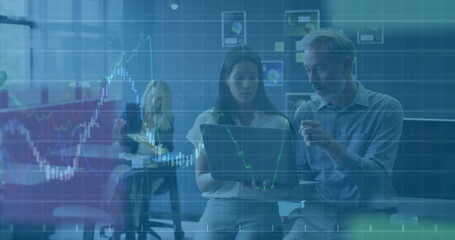 Collaborating coworkers wearing business attire pointing at laptop in meeting room, stock charts
