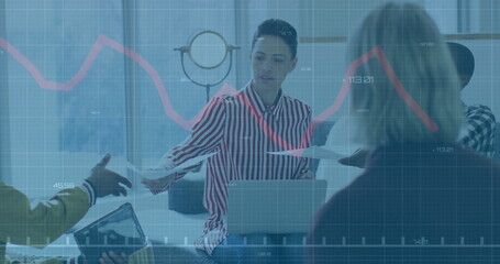 Passing printed documents Hispanic woman in striped blouse at office table, with laptop and tablet