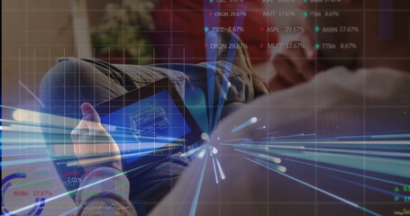 Analyzing blueprint on tablet Asian man wearing sweater on couch in living room, with data overlays