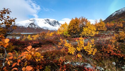Autumnal mountain landscape with vibrant foliage, snow-capped peaks, and a tranquil lake