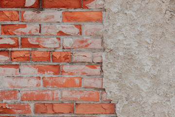 The plaster has crumbled and flaked off the brick wall.