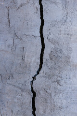Huge crack in the concrete wall of the building.