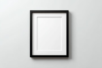 Minimalist black photo frame with white mat on plain wall background.