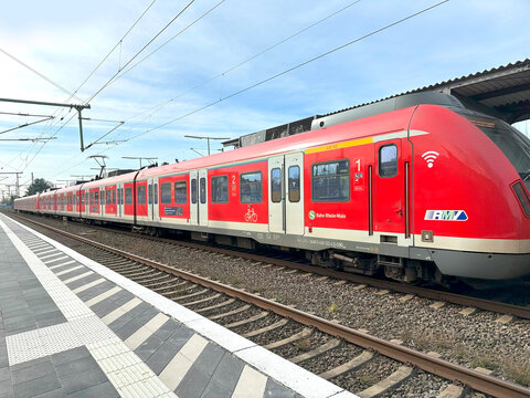 Red S-Bahn Rhein-Main commuter train station platform, modern commuter rail, Deutsche Bahn regional rail service, overhead wires, urban transportation, Frankfurt am Main, Germany transportation