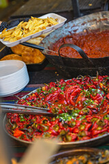 Vivid roasted peppers and crispy fries served at vibrant street food market. Concept of street food, bold flavors, festive fair cuisine