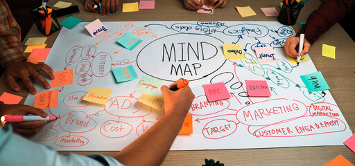 A vibrant brainstorming scene featuring diverse hands creating a mind map with sticky notes and...