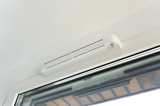 Modern window vent for efficient air supply and comfort. Close-up of trickle vent integrated into a window. Concept of home ventilation, energy-saving design, and climate control technology.