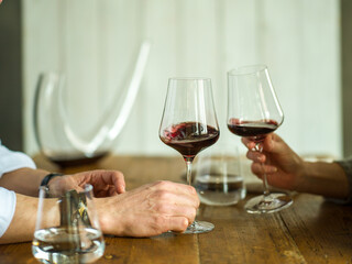 two glasses of red wine making a toast