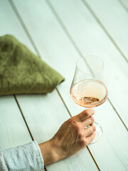 Woman's hand holding a glass of rose wine