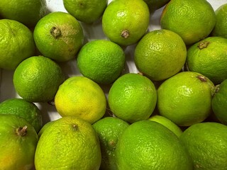 Fresh green limes displayed at market stall