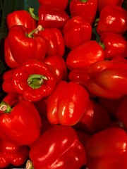 Fresh red bell peppers piled up at market stall
