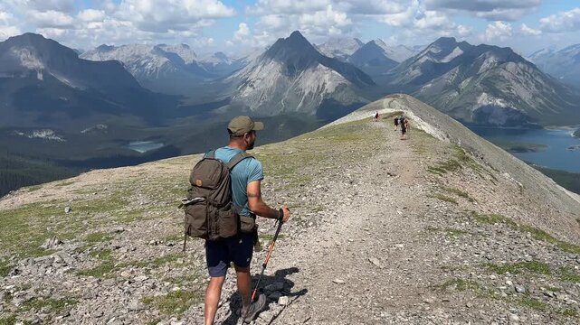 Hispanic male hiker carefully descending Tent Ridge in Kananaskis Country, Alberta