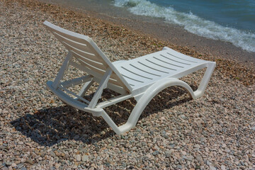 white chaise lounge on the beach