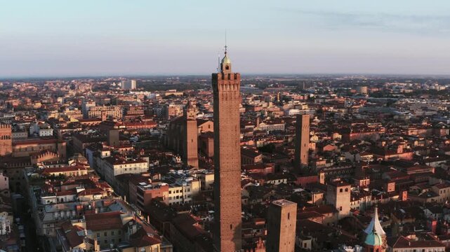 aerial view of the historic city of Bologna, Italy, showcasing the iconic Asinelli Tower prominently in the foreground.  warm golden light, emphasising the rich architectural