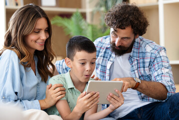 Family enjoying using tablet while relaxing at home