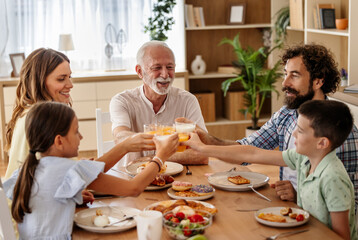 Family of five toasting during their meal in morining