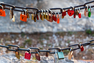 Colorful love padlocks hanging on metal chain. Various colorful padlocks, symbolizing love and...
