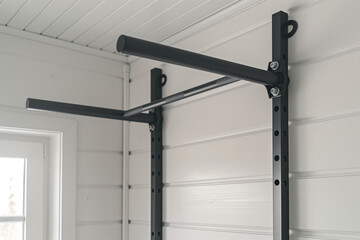 Wall-mounted pull-up bar. Home gym strength training equipment for workouts.