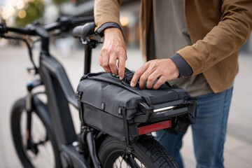 Obraz premium Adjusting bag on electric bike in urban setting