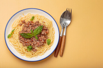 Delicious spaghetti bolognese garnished with fresh basil and grated parmesan, served on a white...