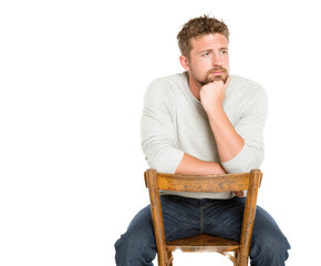 Thoughtful man seated on a wooden chair, lost in contemplation.