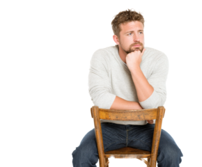 Thoughtful man seated on a wooden chair, lost in contemplation.