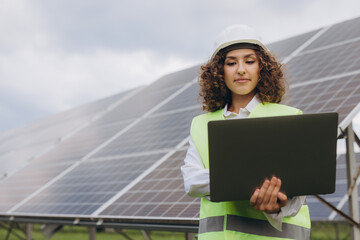 Female engineer working with laptop in solar power station