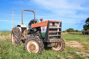 Agricultural tractor painted with the India Flag, outside on the farm in a rural area. Low angle...