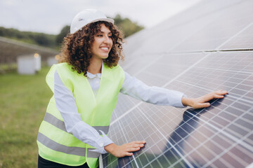 Female engineer inspecting solar panels in a power plant