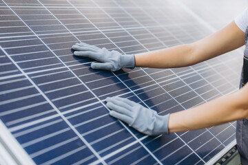 Female technician inspecting solar panel for efficient renewable energy production