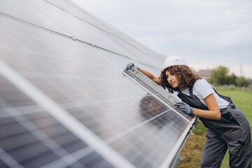 Female engineer checking alignment of solar panels using level tool