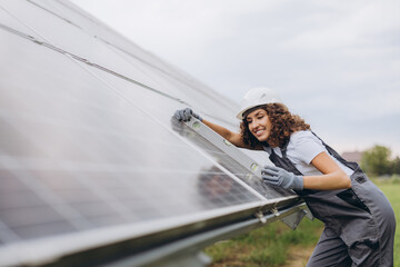 Female engineer working on solar panels using level tool
