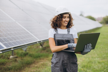 Female engineer working with laptop in solar power station
