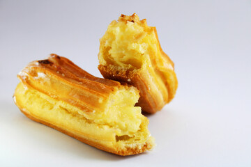 Eclair filled with pastry cream, split in half