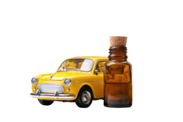 Yellow vintage car beside amber bottle