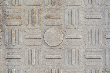 Close-up of textured tactile paving surface with raised rectangular patterns for accessibility and public safety. Useful for infrastructure, mobility, and abstract backgrounds.