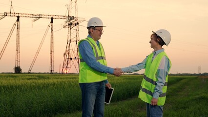 Team of power engineers, construction workers, woman man working together. Power business, partners making deal. Businessman Businesswoman shaking hands. Engineers teamwork, power plant construction