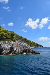 Obraz premium Beautiful Greek island landscape with lush, thick woodland and turquoise tropical waters. Mountains, dense green forests, white rocks and clear blue waters make up the idyllic travel destination.