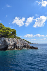 Obraz premium Beautiful Greek island landscape with lush, thick woodland and turquoise tropical waters. Mountains, dense green forests, white rocks and clear blue waters make up the idyllic travel destination.