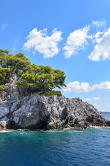 Obraz premium Beautiful Greek island landscape with lush, thick woodland and turquoise tropical waters. Mountains, dense green forests, white rocks and clear blue waters make up the idyllic travel destination.