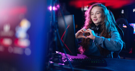 Streamer beautiful girl shows heart sign with hands professional gamer playing online games...